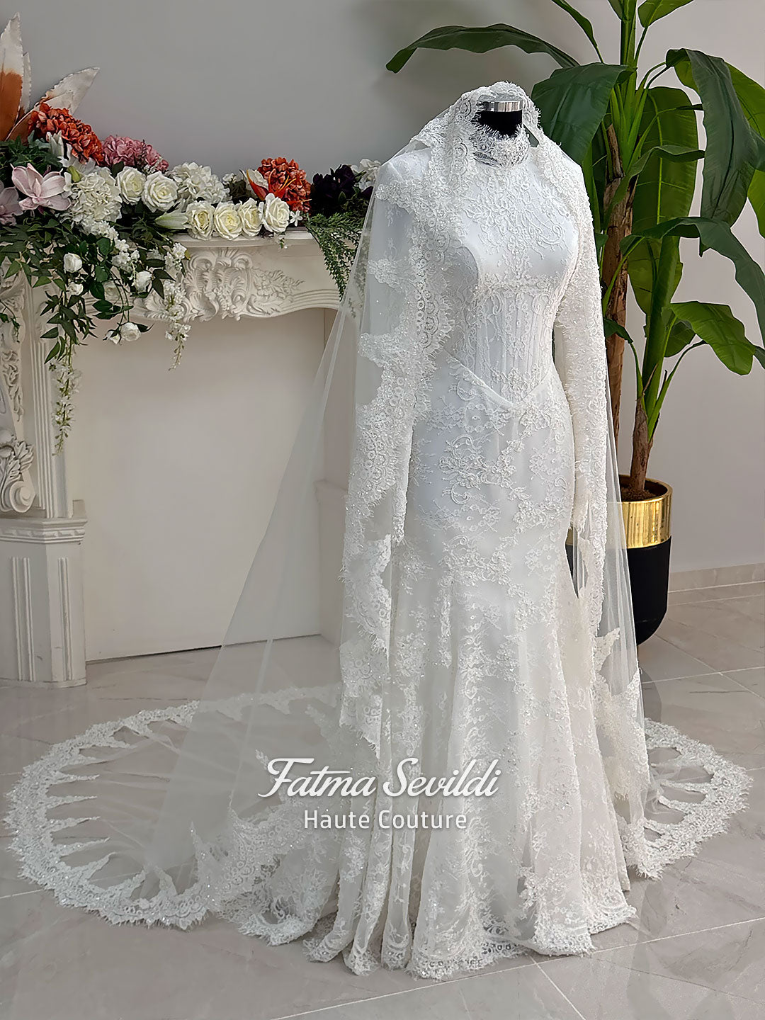 Luxury hijab wedding dress with mermaid silhouette and basque corset, featuring long sleeves, high neck lace, and a premium lace veil. Photographed on a mannequin in a bridal atelier setting.