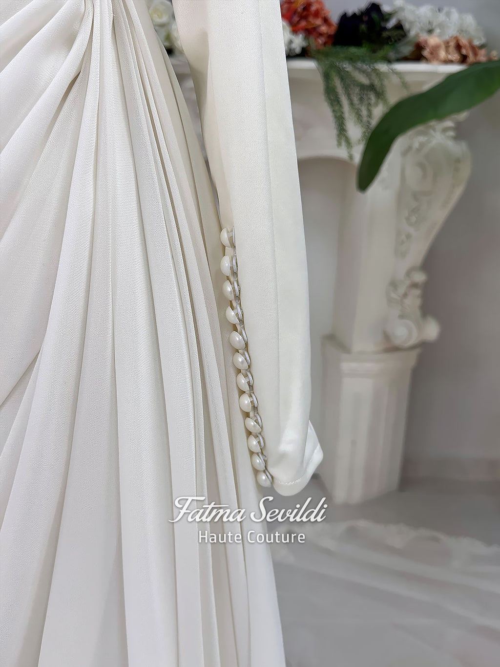Luxury ivory hijab wedding dress with a high neckline, long sleeves, draped satin skirt and included premium lace veil displayed in a bridal atelier.