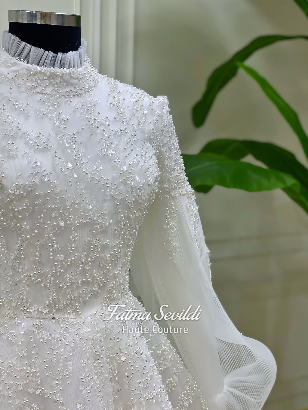Luxury hijab wedding dress in an A-line tulle ball gown silhouette with long balloon sleeves, high neck, sparkling beadwork, and a lace-edged veil.