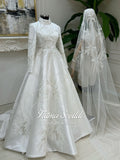 Elegant hijab wedding dress with high neck, long sleeves, and silver starburst beading