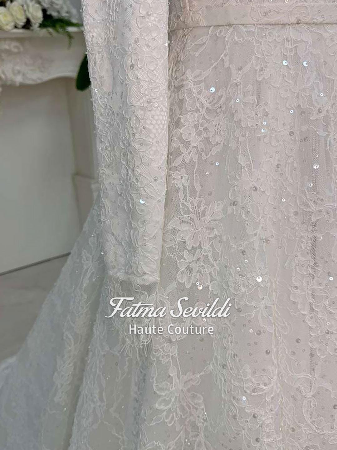 Delicate ivory veiled hijab wedding dress with beaded lace, long sleeves, high neck, floral patterns and sparkling sequins