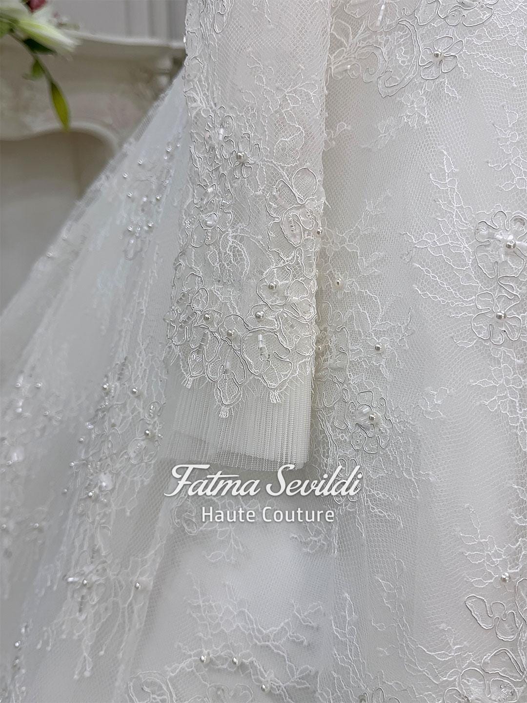 Delicate white lace sleeve with floral embroidery and pearl beads on elegant strapless wedding gown
