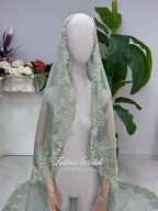 Sage green evening dress with beaded floral lace, a sweetheart neckline and long sleeves with flared lace cuffs, displayed on a mannequin.