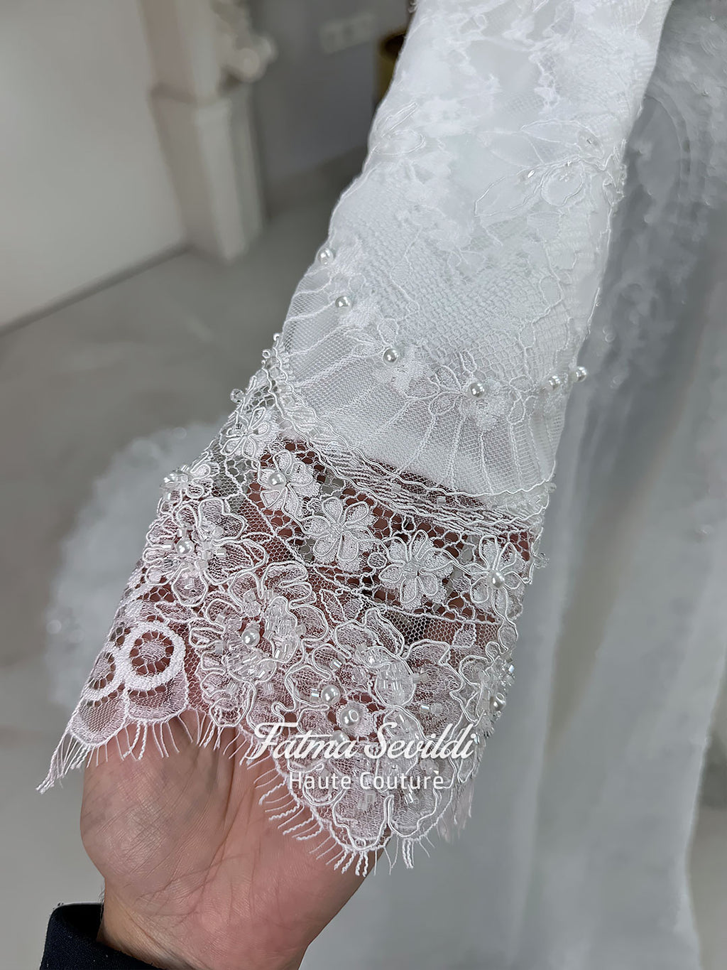 Off-white hijab wedding dress by Fatma Sevildi with beaded floral lace, a basque waist, long sleeves and a high neckline.