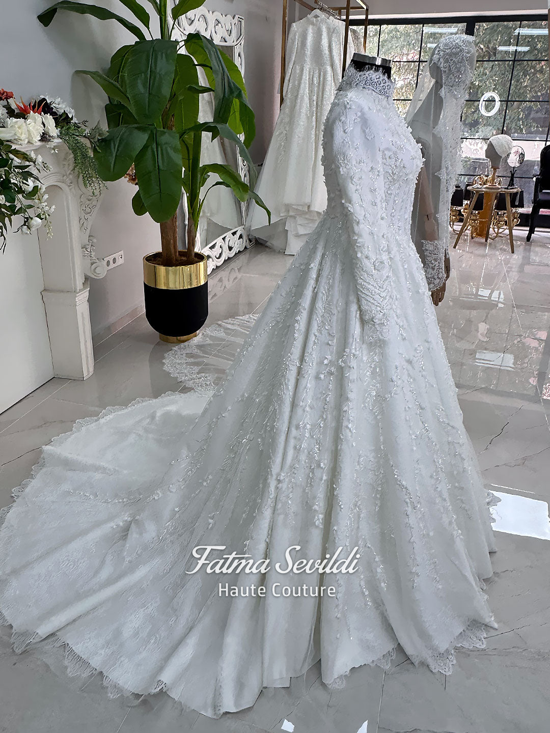 White hijab wedding dress with long sleeves, high lace neckline, floral embroidery and a full modest bridal skirt, shown with a premium lace veil. Luxury Muslim wedding gown with detailed lace and elegant full coverage.