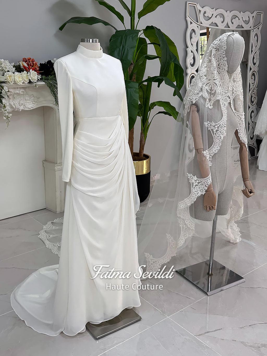 Luxury ivory hijab wedding dress with a high neckline, long sleeves, draped satin skirt and included premium lace veil displayed in a bridal atelier.