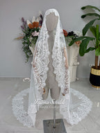 Off-white hijab wedding dress by Fatma Sevildi with beaded floral lace, a basque waist, long sleeves and a high neckline.