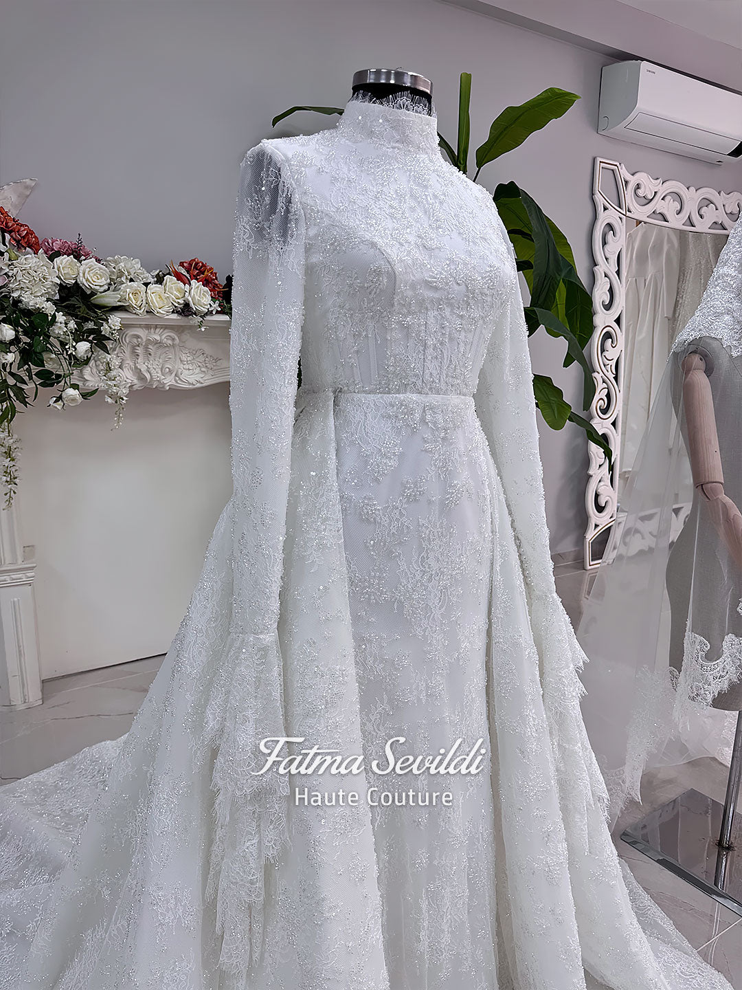 Luxury hijab wedding dress with long flounce sleeves, a high mock neckline, beaded floral lace, corset fit, mermaid silhouette, detachable overskirt, and included lace veil. Modest Muslim bridal gown shown from front, back, and detail views.