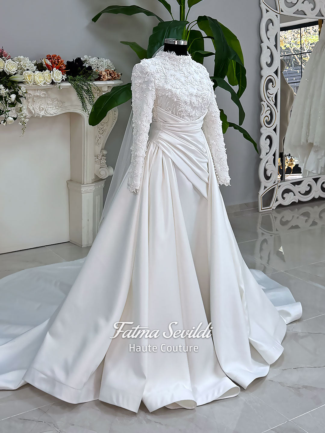 Luxury modest hijab wedding dress with long sleeves, 3D floral beaded lace bodice, draped satin A-line skirt and lace-edged veil included, shown on mannequin. Custom made Islamic bridal gown with elegant full coverage.