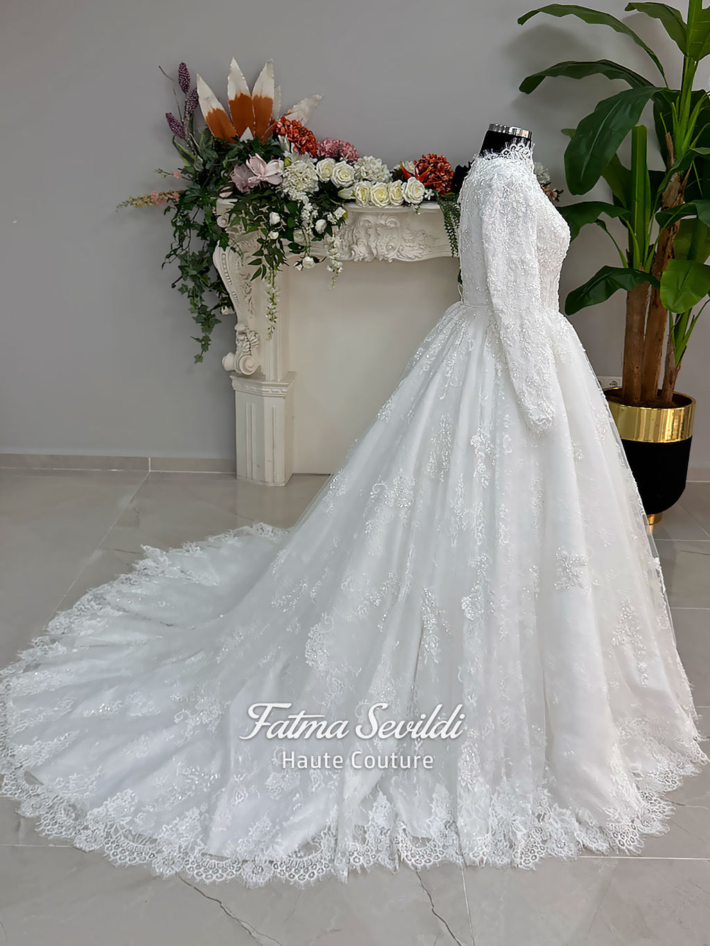 Luxury modest hijab wedding dress ball gown with long sleeves, high neck corset bodice, lace appliqué and included lace veil, photographed in a bridal atelier.