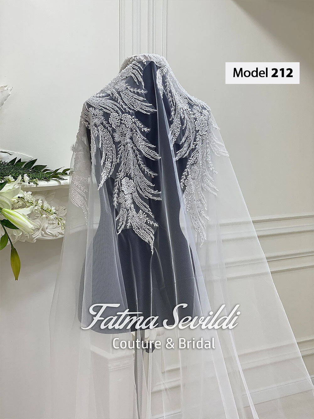 Elegant sheer white veil with silver beaded feathers on gray velvet