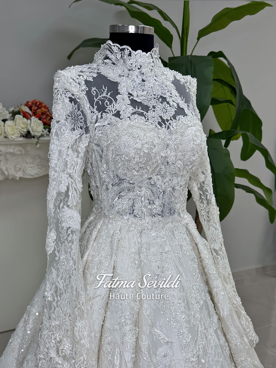 Ivory luxury hijab wedding dress featuring long lace sleeves, a high neckline, full beaded floral lace princess skirt, dramatic train and coordinating premium lace veil.