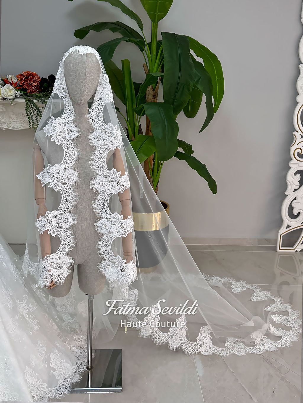 Luxury modest hijab wedding dress ball gown with long sleeves, high neck corset bodice, lace appliqué and included lace veil, photographed in a bridal atelier.