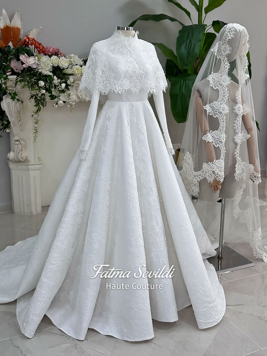 Elegant hijab wedding dress with long sleeves, high neck, detachable lace cape, cathedral train, and premium lace veil included. Luxury modest bridal couture gown in white with floral lace detailing.