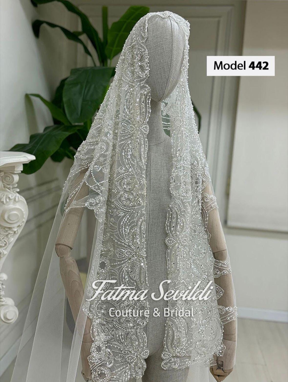 Delicate white beaded veil with floral embroidery on mannequin, for modest Muslim bridal gown