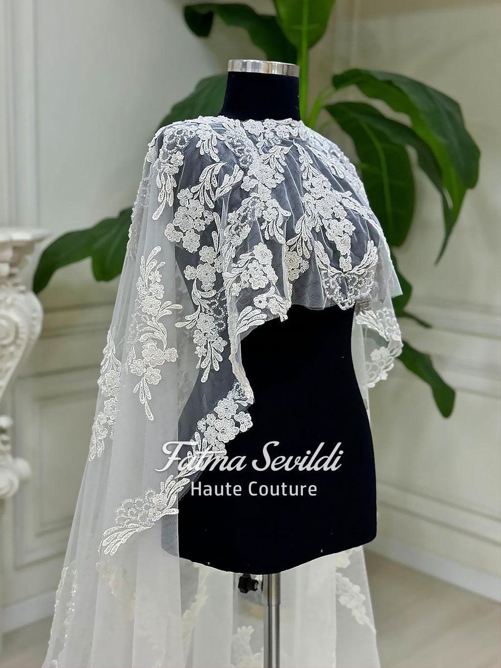 Elegant white lace bridal cape veil with floral embroidery on mannequin