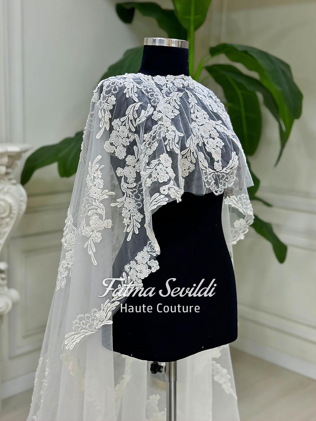 Elegant white lace bridal cape veil with floral embroidery on mannequin