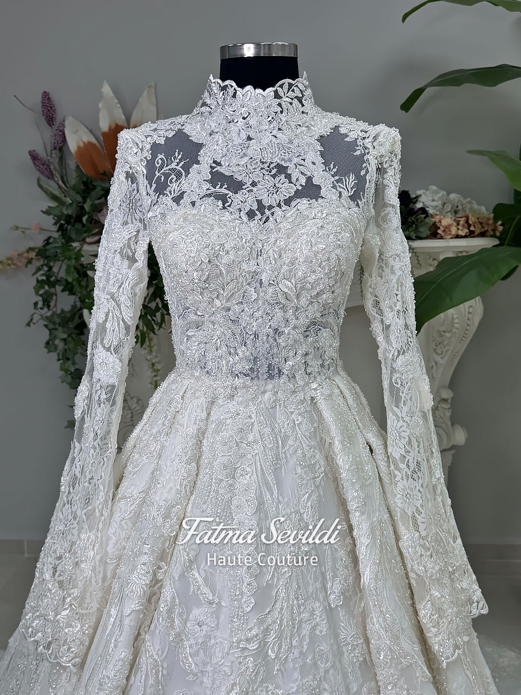 Ivory luxury hijab wedding dress featuring long lace sleeves, a high neckline, full beaded floral lace princess skirt, dramatic train and coordinating premium lace veil.