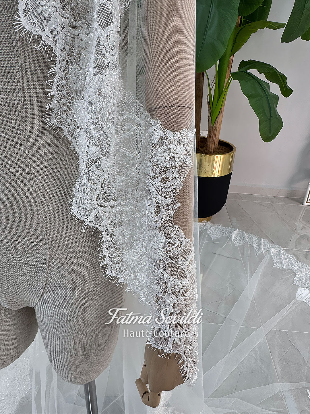 White hijab wedding dress with long sleeves, high lace neckline, floral embroidery and a full modest bridal skirt, shown with a premium lace veil. Luxury Muslim wedding gown with detailed lace and elegant full coverage.
