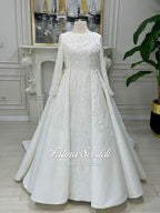 White beaded lace Muslim wedding dress with long sleeves and flowing skirt