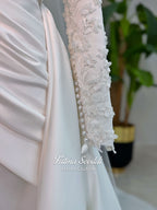 Luxury modest hijab wedding dress with long sleeves, 3D floral beaded lace bodice, draped satin A-line skirt and lace-edged veil included, shown on mannequin. Custom made Islamic bridal gown with elegant full coverage.
