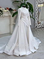 Luxury modest hijab wedding dress with long sleeves, 3D floral beaded lace bodice, draped satin A-line skirt and lace-edged veil included, shown on mannequin. Custom made Islamic bridal gown with elegant full coverage.