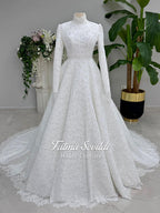 Elegant white long-sleeve Muslim bridal gown with beaded lace cape and high neck A-line design