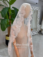Delicate white lace veil with floral patterns on mannequin