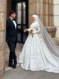 Elegant white lace Muslim wedding gown with flowing veil by Fatma Sevildi