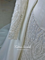 Luxury hijab wedding dress with long sleeves, high neck, beaded lace mermaid silhouette and detachable overskirt, veiled bridal set. Handmade couture modest bridal gown with lace-up corset back and sparkling embroidery.