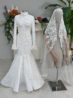 3-in-1 white hijab wedding dress with a beaded mermaid gown, detachable overskirt and long sleeve high-neck bridal topper. Convertible modest bridal set with dimensional floral lace and a coordinating lace veil.