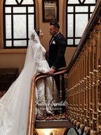 Fatma Sevildi Couture lace wedding dress on a mannequin, featuring a high neckline, long sleeves and intricate floral embellishment.