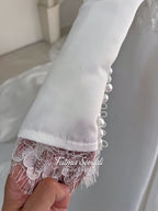 White A-line satin hijab wedding dress with long sleeves, high neckline, floral appliqué embroidery and an included premium lace mantilla veil for a modest Muslim bridal look.