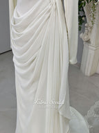 Luxury ivory hijab wedding dress with a high neckline, long sleeves, draped satin skirt and included premium lace veil displayed in a bridal atelier.
