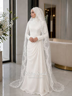 Luxury ivory hijab wedding dress with a high neckline, long sleeves, draped satin skirt and included premium lace veil displayed in a bridal atelier.