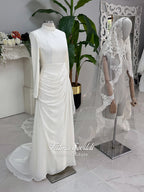 Luxury ivory hijab wedding dress with a high neckline, long sleeves, draped satin skirt and included premium lace veil displayed in a bridal atelier.