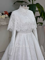 Elegant hijab wedding dress with long sleeves, high neck, detachable lace cape, cathedral train, and premium lace veil included. Luxury modest bridal couture gown in white with floral lace detailing.