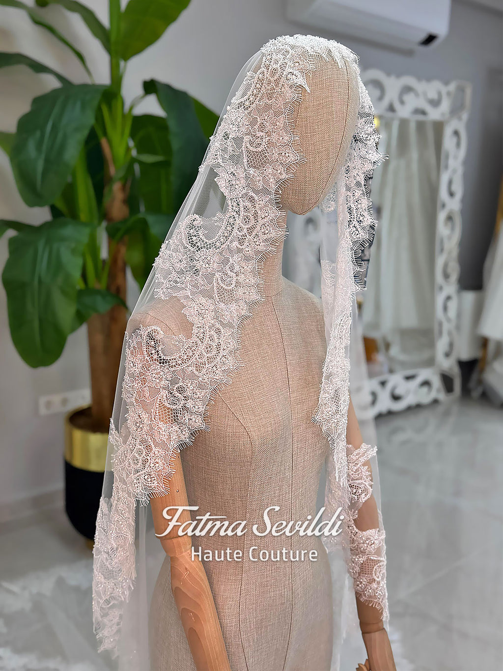 Delicate white lace veil with floral patterns on mannequin