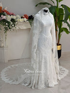 Luxury hijab wedding dress with mermaid silhouette and basque corset, featuring long sleeves, high neck lace, and a premium lace veil. Photographed on a mannequin in a bridal atelier setting.