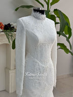 Luxury hijab wedding dress with mermaid silhouette and basque corset, featuring long sleeves, high neck lace, and a premium lace veil. Photographed on a mannequin in a bridal atelier setting.