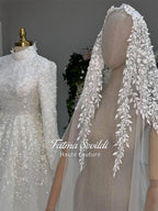 Delicate white lace veil with leaf berry embroidery beside modest hijab wedding gown