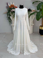 Ivory long sleeve hijab wedding dress with detachable lace-edged cape, floral beaded embroidery, high neckline and floor-length A-line modest bridal silhouette. Designed for Muslim brides seeking an elegant luxury wedding gown with full coverage.