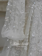 Luxury Muslim wedding dress with high neck, long sleeves, beaded lace embroidery, full A-line skirt, and matching premium lace veil. Elegant modest bridal gown custom made for hijab brides seeking a couture wedding look.