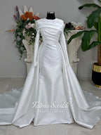 Luxury satin hijab wedding dress with off-shoulder long sleeves and an A-line silhouette, shown with premium lace veil and dramatic train. Custom couture modest bridal gown design with elegant draping and pearl details.