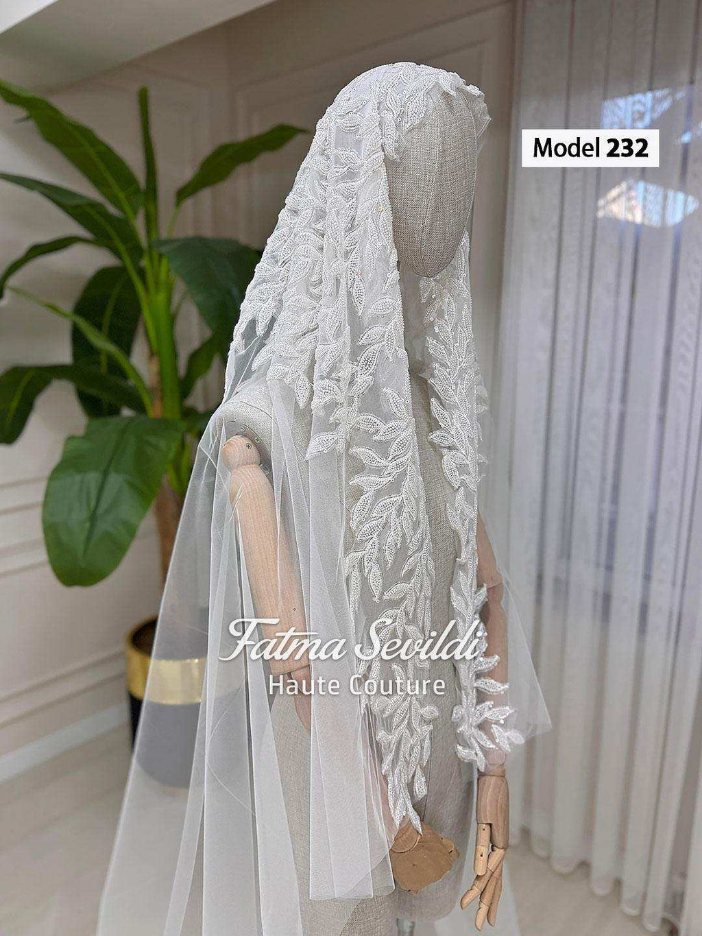 Elegant white lace veil with leaf embroidery on mannequin