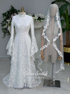 Veiled hijab wedding dress with high neck, long sleeves, and beaded floral lace in an elegant A-line couture silhouette.