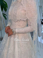 Delicate ivory lace wedding gown with veiled hijab capelet, long sleeves, high neck