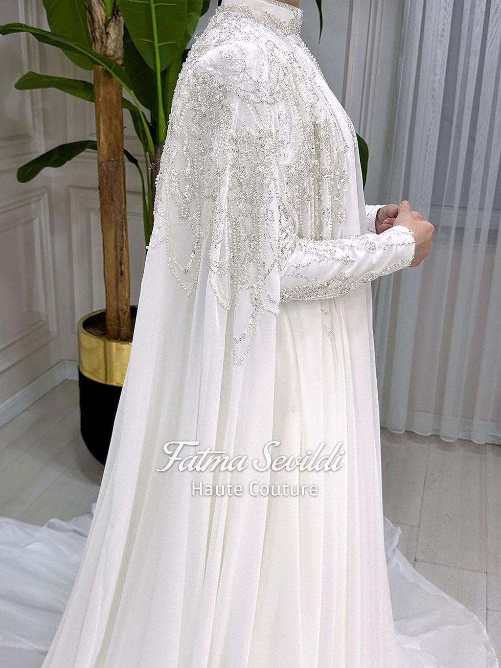 Elegant white satin Muslim wedding dress by Fatma Sevildi with silver beading