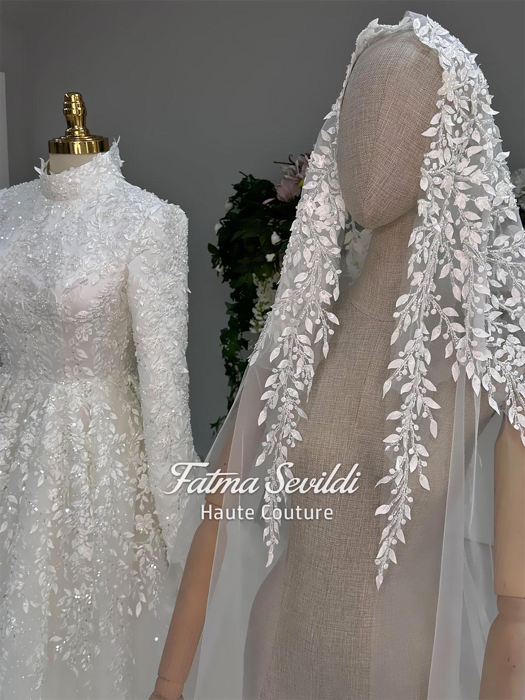 Delicate white lace veil with leaf berry embroidery beside modest hijab wedding gown