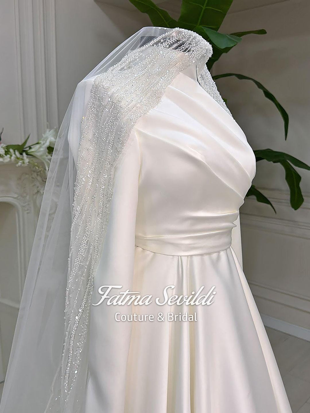 Elegant ivory satin Muslim wedding gown with high neck, long sleeves, and beaded veil